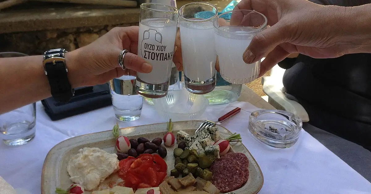 Top 10 Greek liquors: friends clinking glasses of ouzo