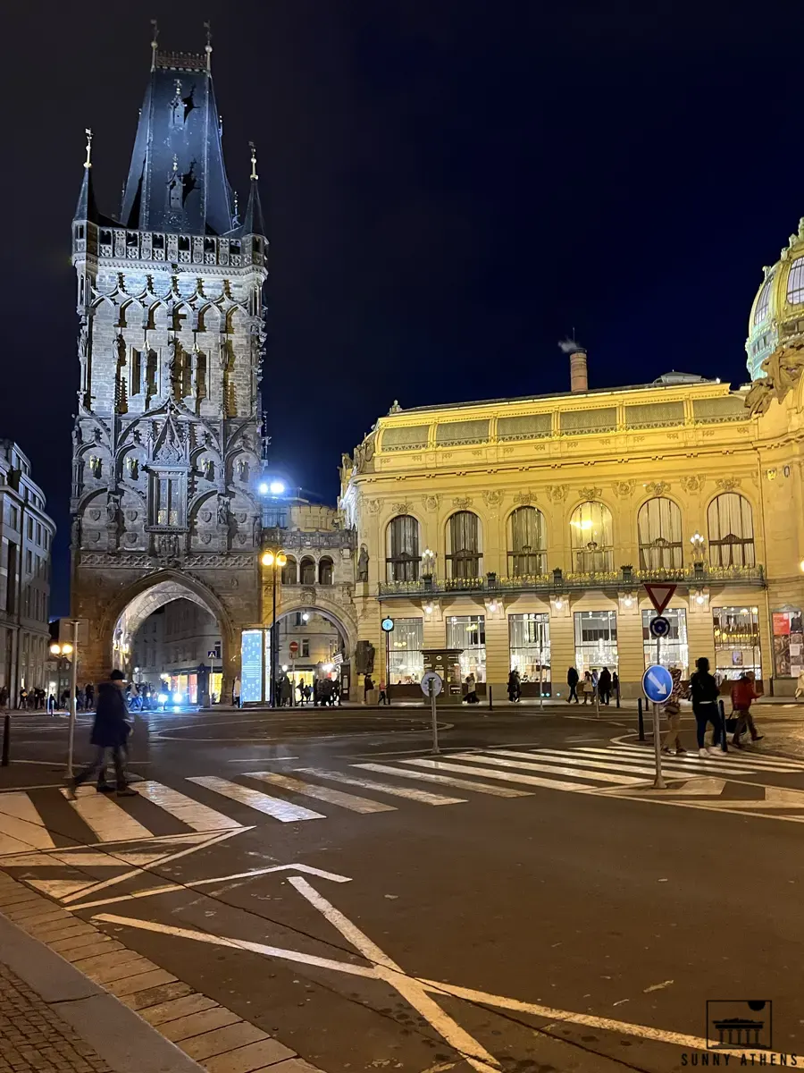 People walking in front of the Powder Tower at night