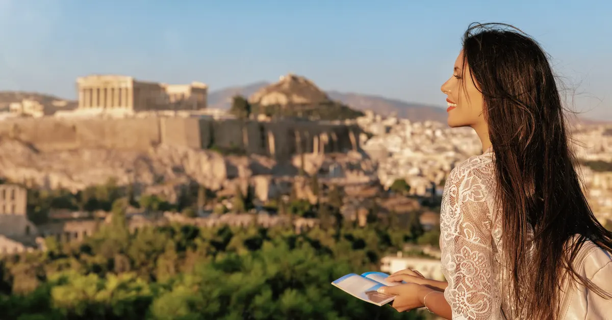 Athens Tours: a girl with a guidebook looking at Acropolis