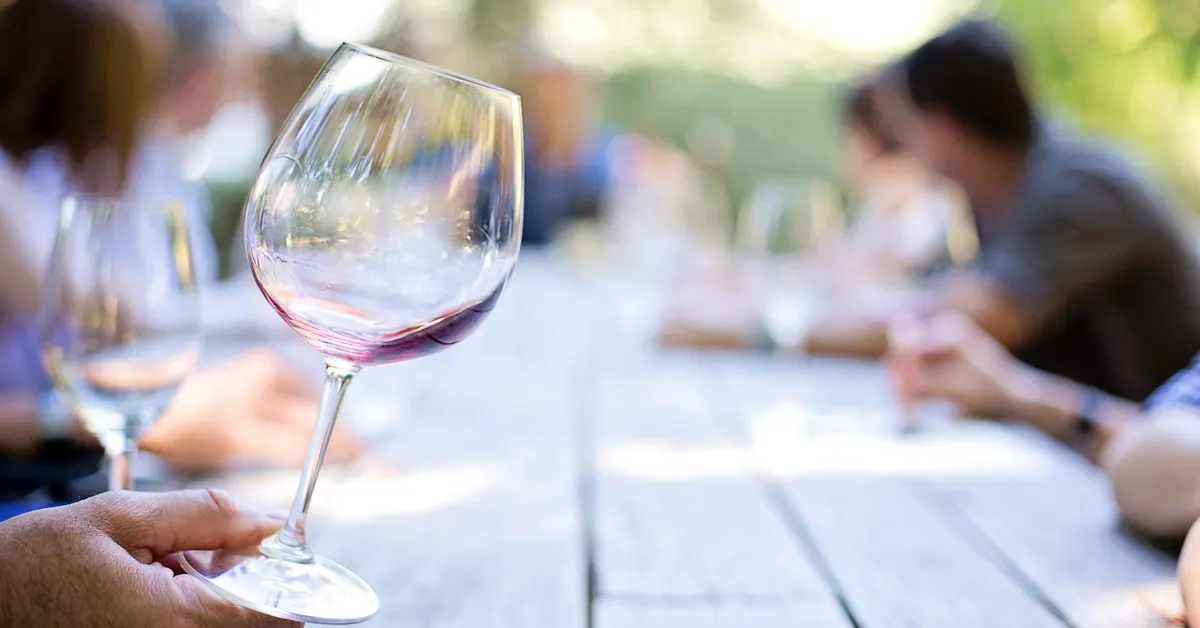 A hand holding a glass of wine