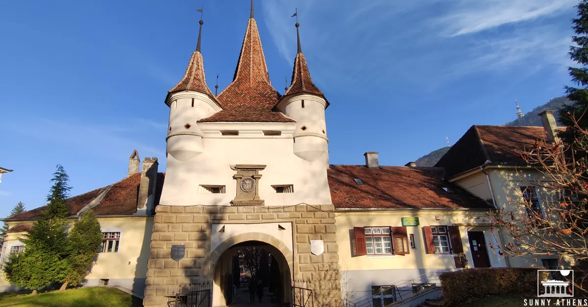 Catherine's Gate in Brasov, with three towers on its top and a gate beneath them.