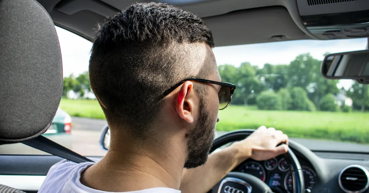 Young man driving a car.