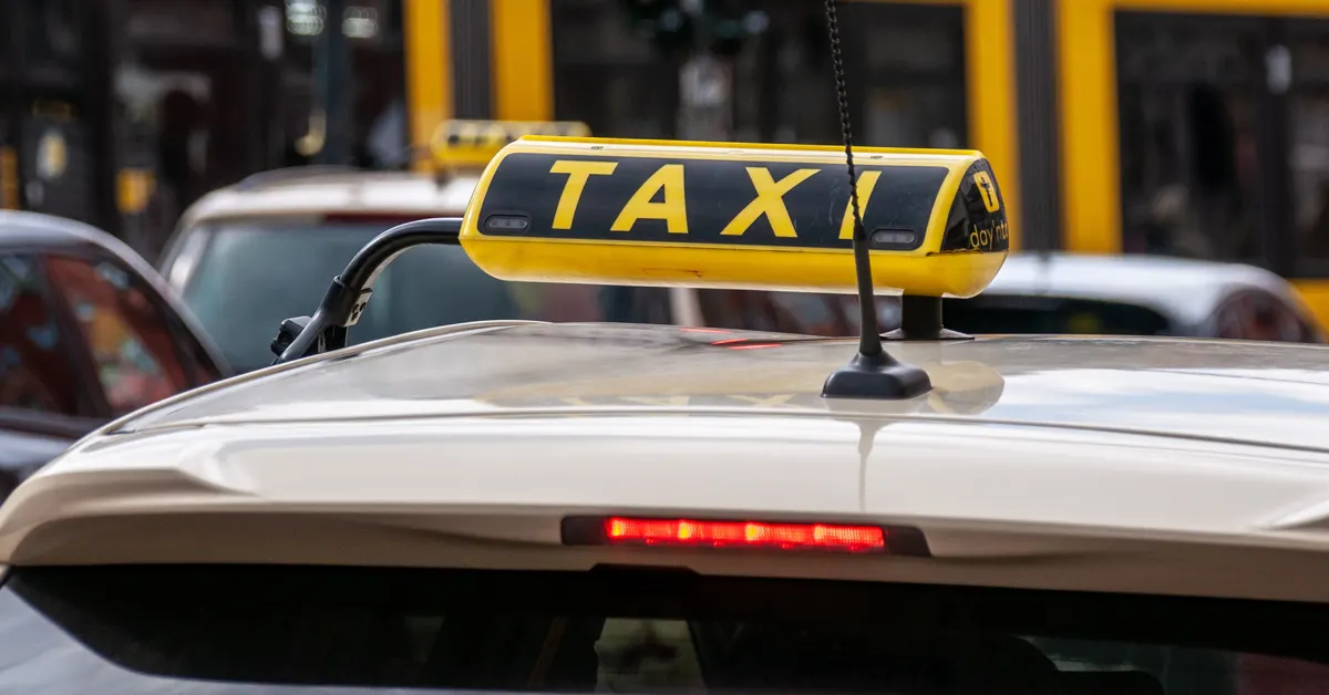 A taxi sign clearly visible in the daylight.