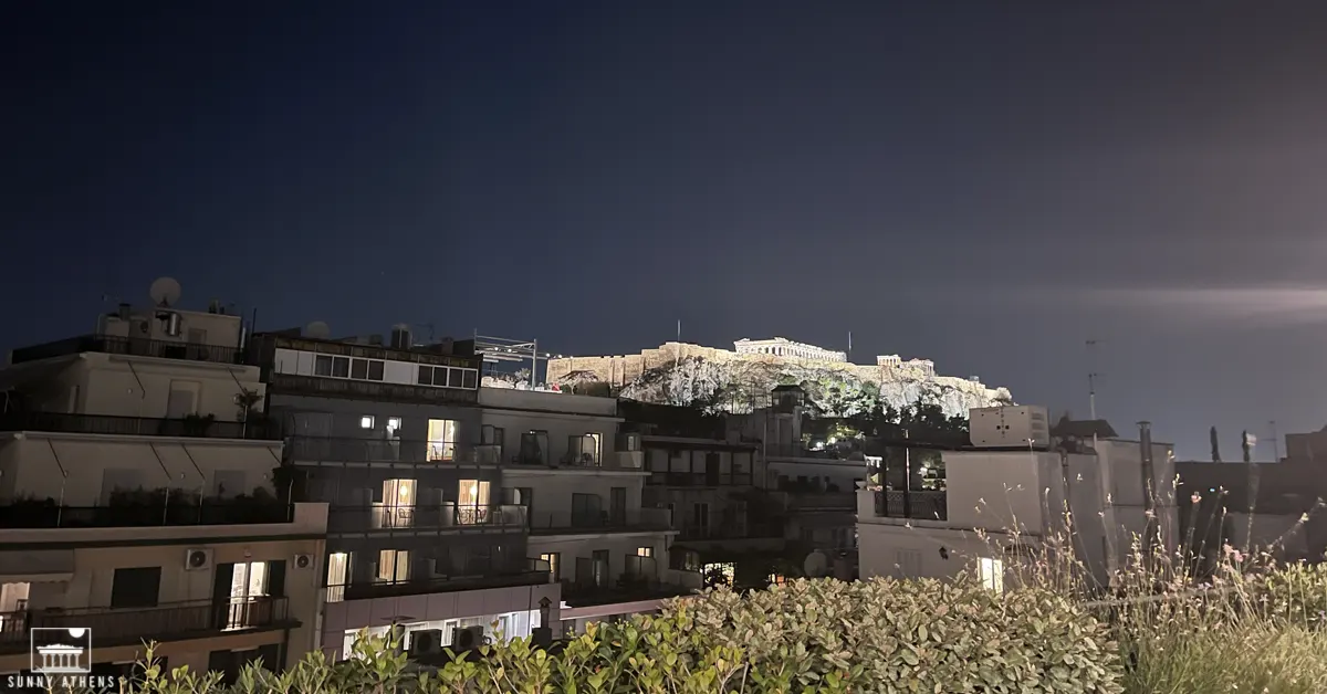 Best Rooftop Bars in Athens: A night view of the Acropolis from Ergon House rooftop.