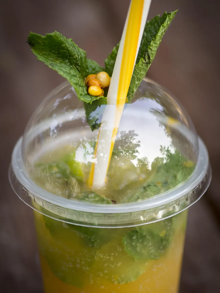 A refreshing plastic glass filled with mint lemonade.