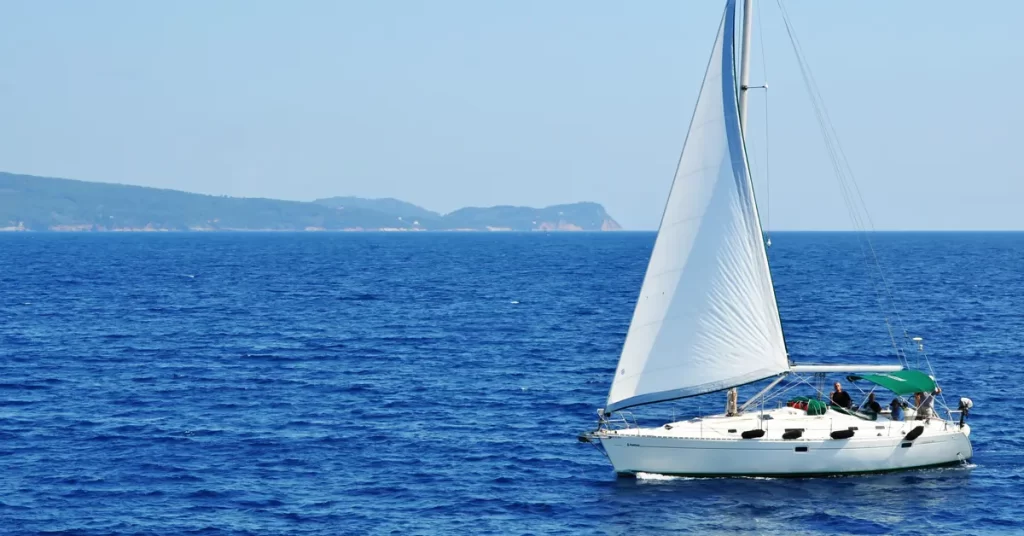 Best day trips from Athens: a sailboat cruising on a vast blue sea.