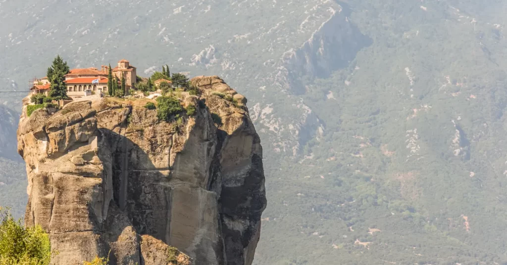 Best day trips from Athens: a monastery perched on a massive rock pillar at Meteora, Greece.