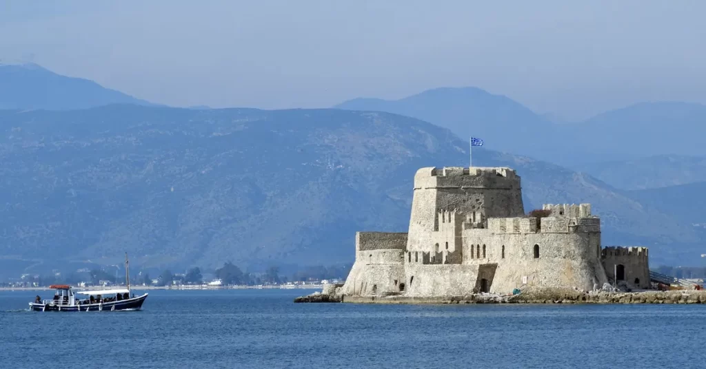 A boat sails towards the stone castle of Mpourtzi at Nafplio.