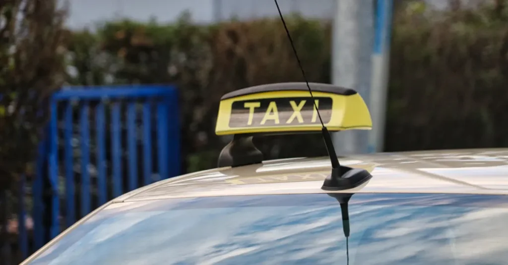 Close-up of a taxi sign on the roof of a car.