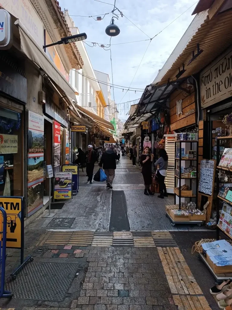 Ifestou flea market in Monastiraki, with people walking around.