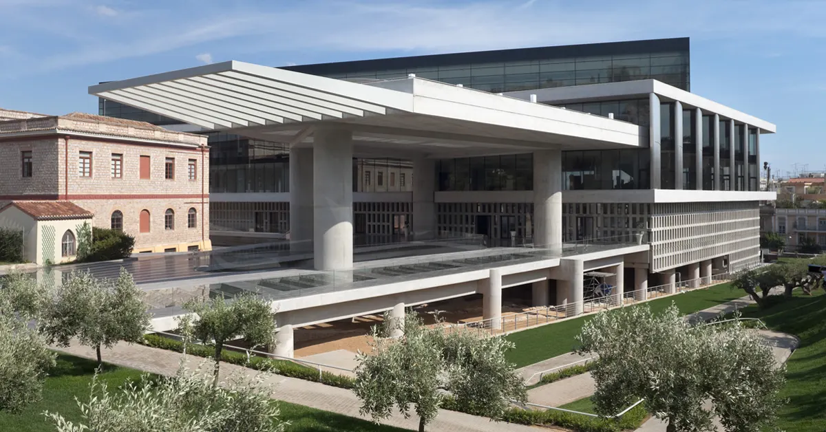 Best museum in Athens: Exterior view of the Acropolis Museum's front side, with olive trees in the foreground.