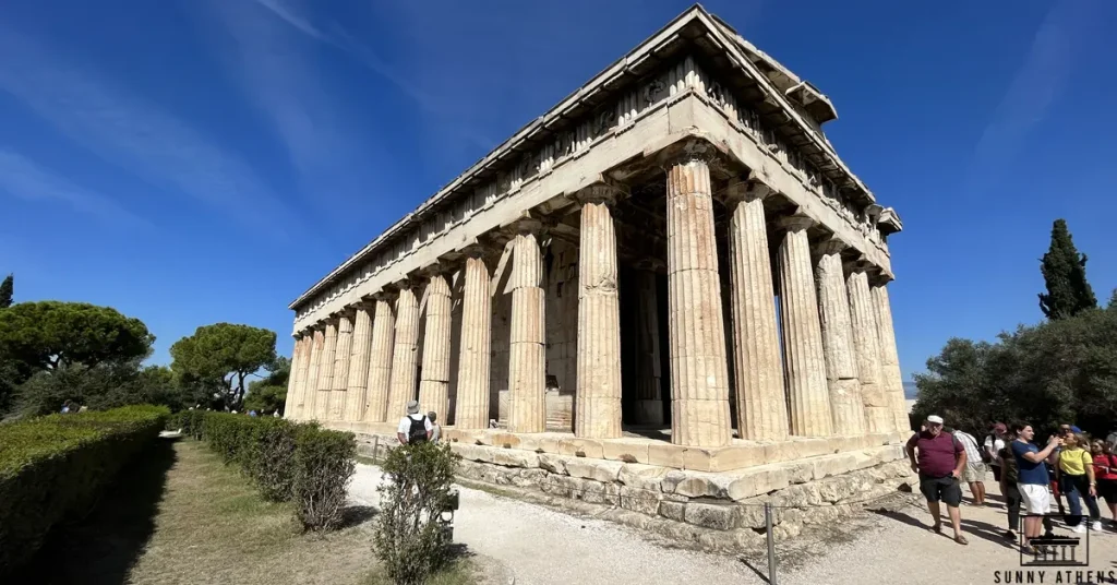 View of the Temple of Hephaestus in the Ancient Agora of Athens, with visitors around it.