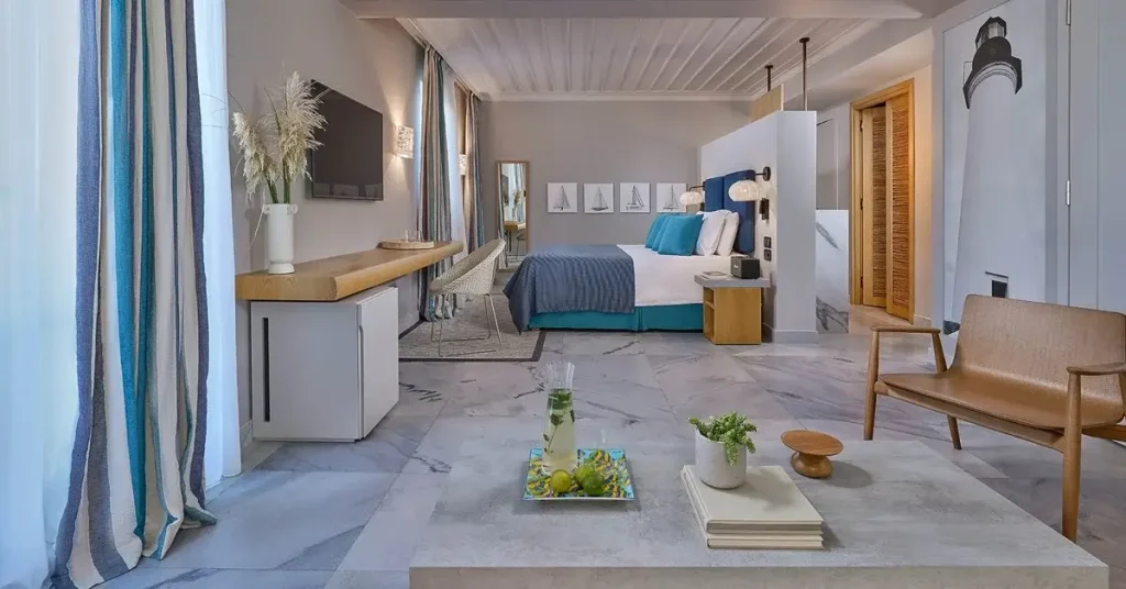 A finely decorated room at Summer Senses hotel in Paros, Greece, featuring marble flooring and blue curtains at the side.