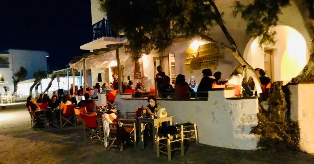 People sitting and chatting at Resalto, the rock bar on Dryos Beach in Paros.