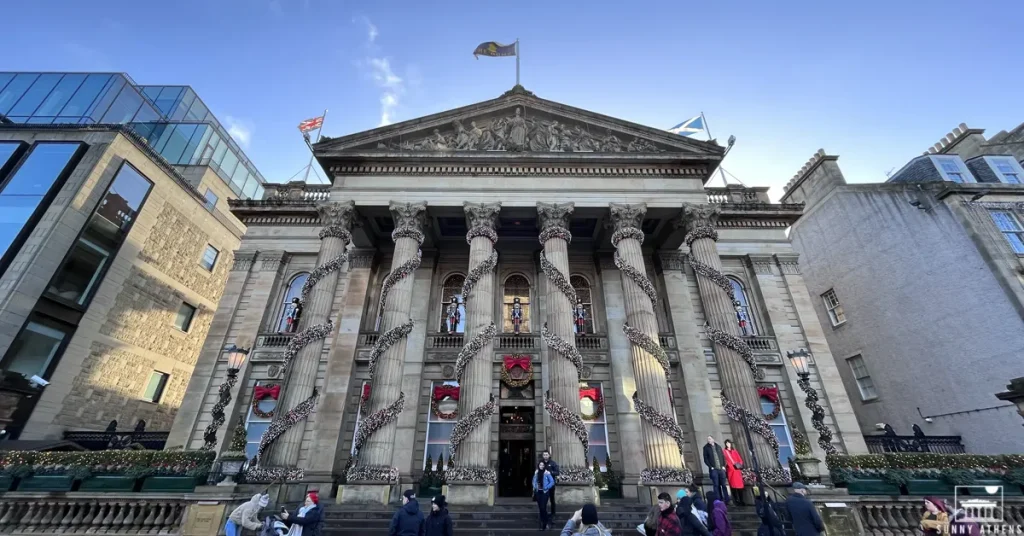 The Christmas-decorated facade of The Dome, with several people taking photos in front of it.