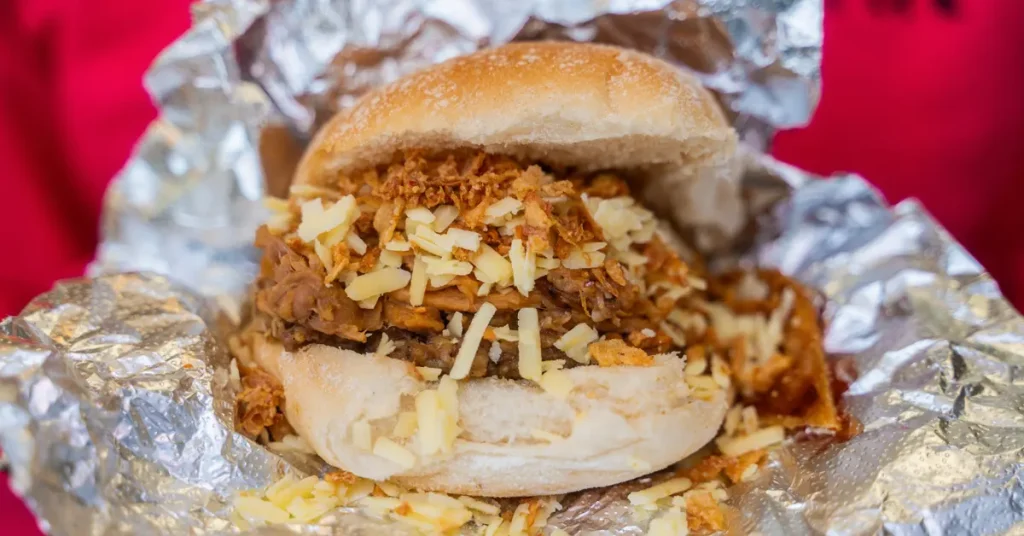 A pulled pork sandwich from Oink Victoria Street served in aluminum foil.