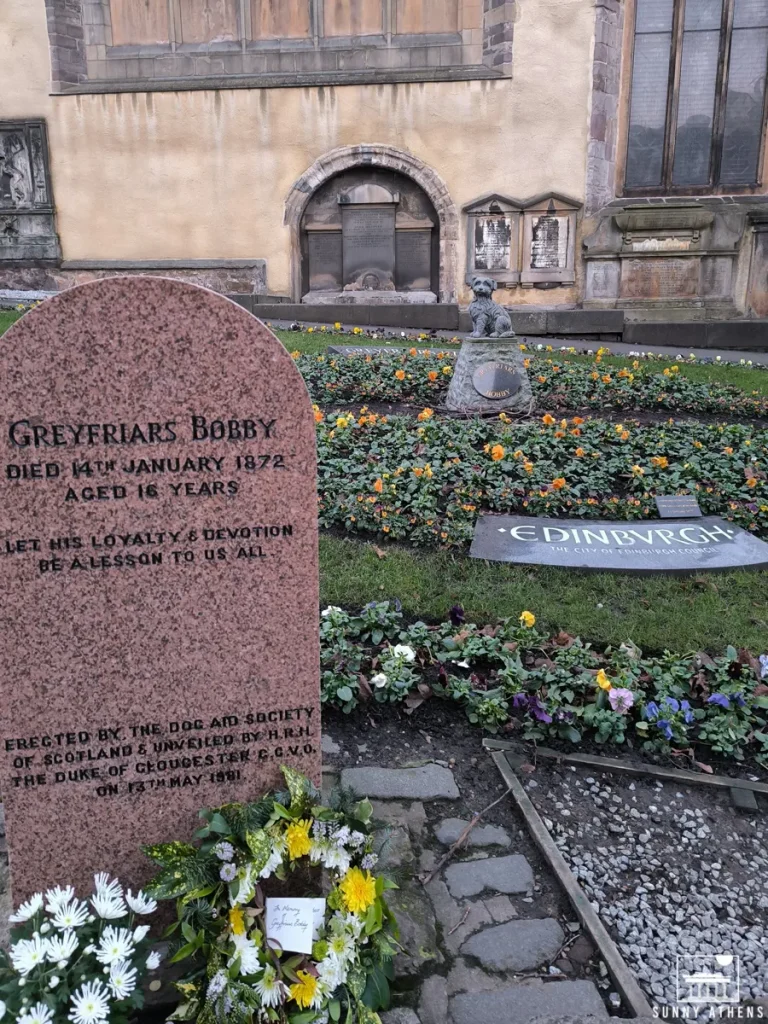 Grave of Greyfriars Bobby adorned with flowers, a monument to visit on a 4-day Edinburgh tour.