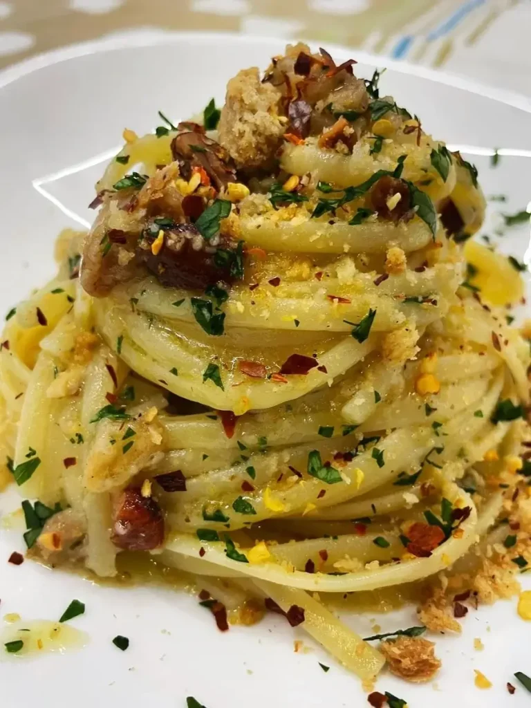 A delectable pasta dish from Mamma Mia Italian restaurant, garnished with dill, chili flakes, and grated cheese.