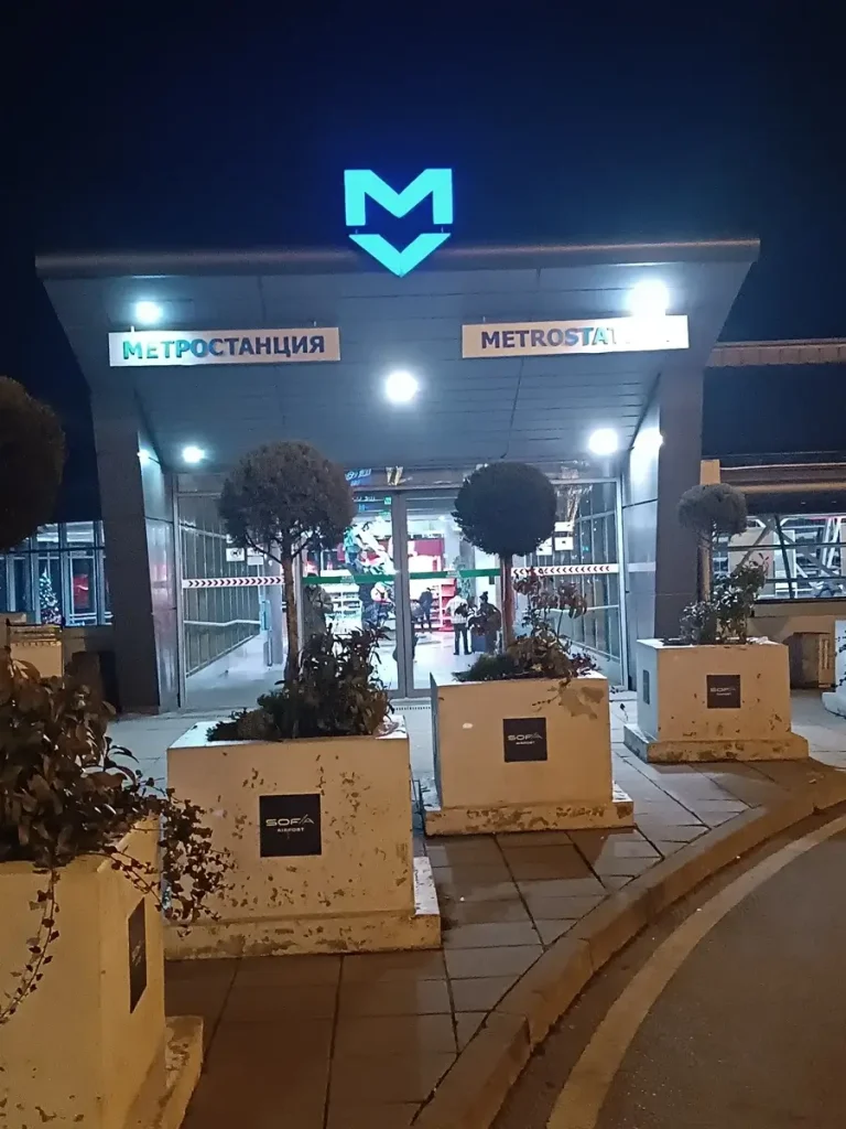 The entrance of the metro station at Sofia airport, illuminated at night.