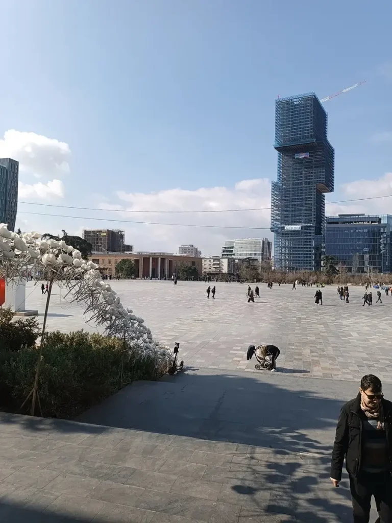 Panoramic view of the Skanderbeg Square with people walking by.