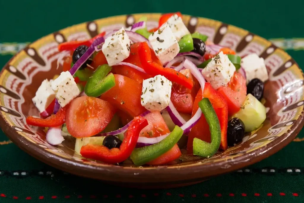 A delicious Greek salad featuring tomatoes, cucumbers, green peppers, onions, olives, and feta cheese.