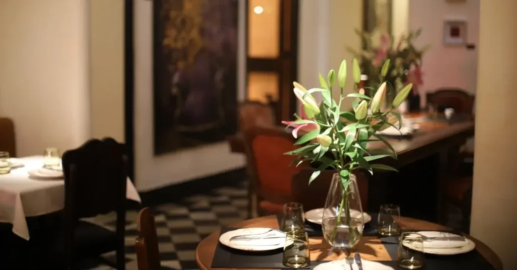 Wooden chairs and tables, and black-and-white tiles in the interior of the must-try Grande Dame restaurant in Plaka, Athens.