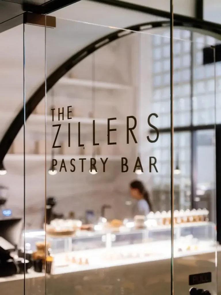 The glass storefront door of The Zillers Pastry, with its name displayed on the door.