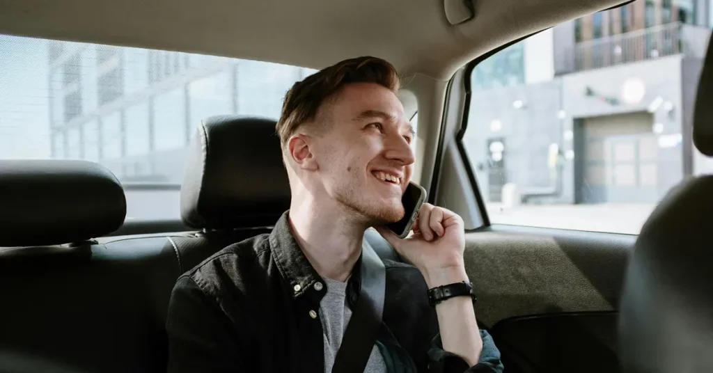 Bolt in Athens: A man smiling while talking on the phone in a taxi.